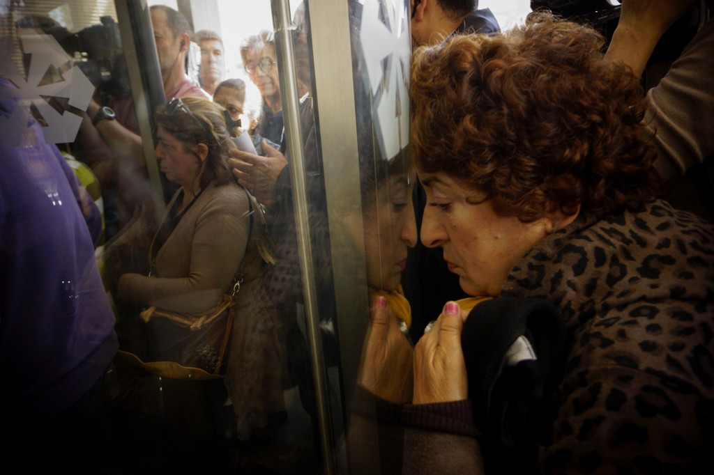 CYPRUS, Nicosia : People queue up outside a Laiki bank branch in the Cypriot capital, Nicosia, on March 28, 2013, as they wait for the bank to open after an unprecedented 12-day lockdown. Queues of dozens of people formed before the doors swung open at 12:00pm (1000 GMT) for the first time since March 16, and there were tensions as a few branches opened late, with customers banging on the doors